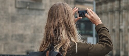 woman taking a photo during college touring